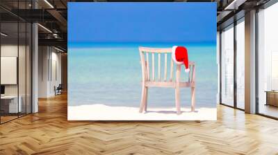 Red santa hat on beach chair at tropical vacation Wall mural