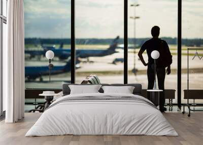 Silhouette of a man waiting to board a flight in airport Wall mural