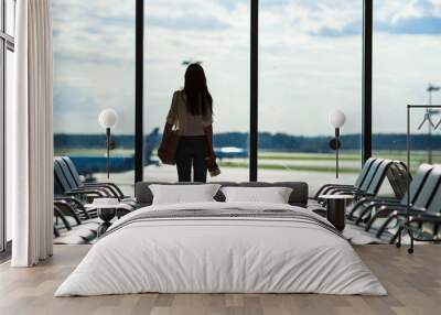 Silhouette of woman in an airport lounge waiting for flight Wall mural