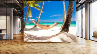 Straw hammock in the shadow of palm on tropical beach by sea Wall mural