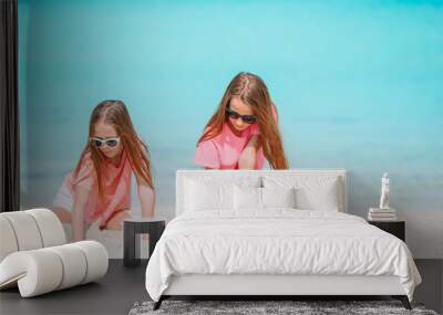 Two little happy girls have a lot of fun at tropical beach playing together Wall mural