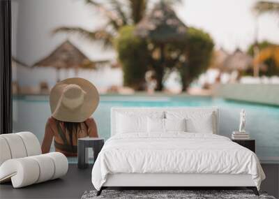 Woman relaxing by the pool in a luxury hotel resort enjoying perfect beach holiday vacation Wall mural