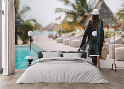 Woman relaxing by the pool in a luxury hotel resort enjoying perfect beach holiday vacation Wall mural