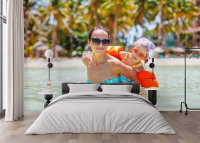 Young beautiful mother having fun with her daughter on tropical beach vacation Wall mural