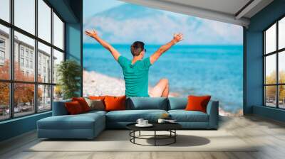 Young man on the white beach on vacation Wall mural