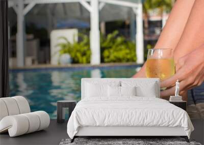 Young woman with a glass of white wine near the pool Wall mural