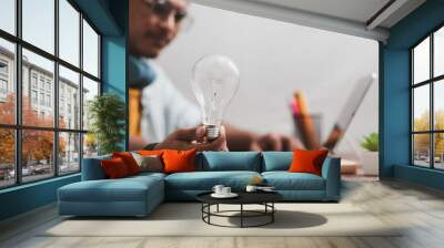 business man holding a light bulb and brain graphic inside Represents business networking technology ideas. Wall mural