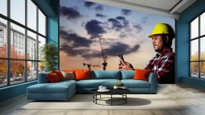 silhouette engineer or field businessman uses a smartphone to contact a construction plan for a beautiful sunset home project. Wall mural