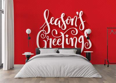 SEASON’S GREETINGS brush calligraphy on red giftwrap background Wall mural