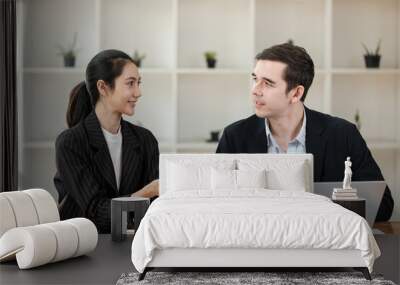 Two people in suits are talking in a room with a lot of plants Wall mural