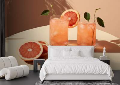 Two glasses with fresh grapefruit summer cocktail and ice cubes Wall mural