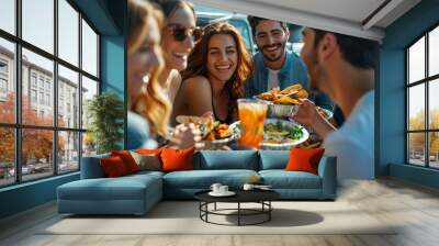 Group of friends enjoying an outdoor meal, laughing and sharing food at a picnic table. Vibrant, sunny atmosphere and cheerful expressions. Wall mural