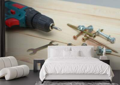 set of tools on wooden table, a electric screwdriver with a set of drill bits and screws with bolts. work tool on wooden background. Hand tool closeup Wall mural