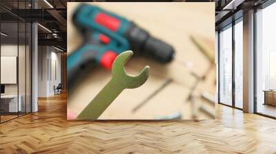 set of tools on wooden table, a electric screwdriver with a set of drill bits and screws with bolts. work tool on wooden background. Hand tool closeup Wall mural