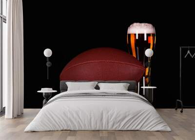 Beer glass with foam and American football ball on black background Wall mural