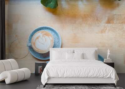 Top view of two cups of fresh cappuccino with heart foam and a sweet pastry bun on the table Wall mural