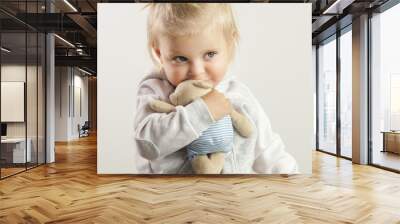 An adorable baby girl hugging with her favorite soft toy Wall mural