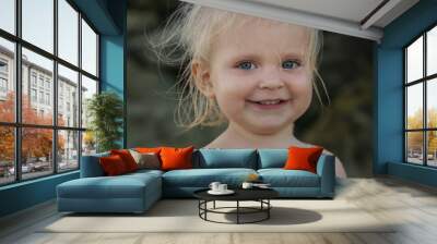 Candid outdoor headshot of adorable blond toddler girl Wall mural