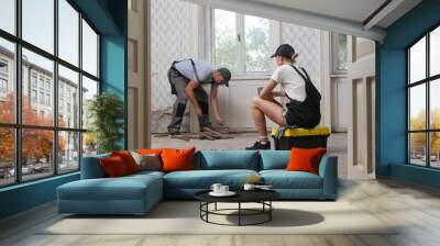 Couple renovating their own apartment. Home improvement and DIY project. Young couple is removing old wooden floor, making repairs to their home Wall mural