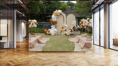 Creative gender neutral baby shower or birthday decoration in the garden. Bohemian style outdoor event set up with balloons. White cream peach caramel balloon arch kit. Wall mural