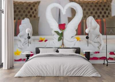 Luxury hotel bedroom interior with honeymoon decoration, Towel swans and rose flowers on the bed Wall mural