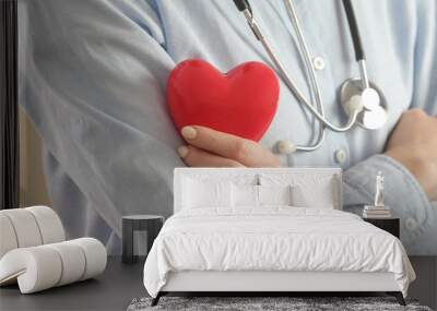 Medical worker holding a red heart as a symbol of health, health care  concept Wall mural