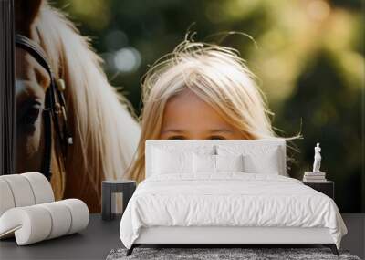 Portrait of cute happy smiling little girl with horse on a beautiful summer day. Interacting with horses encourages emotional bonding and can help children develop trust, empathy, confidence and helps Wall mural