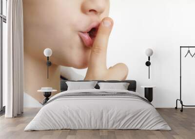 Studio shot of young boy with finger on lips - silent gesture Wall mural