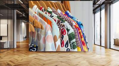 
Variety of colorful shirts hanging on the wooden hangers, close up  Wall mural