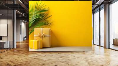 Vibrant yellow wall with two gift boxes and a palm leaf on top Wall mural