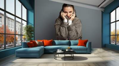 Beauty with warm coatYoung cheerful attractive woman wearing a grey coat during autumn and winter, isolated on grey studio background Wall mural