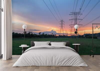 Group silhouette transmission towers (steel lattice/power tower, electricity pylon) next to apartment complex at sunset in US. Texture high voltage pillar, overhead power line, industrial background. Wall mural