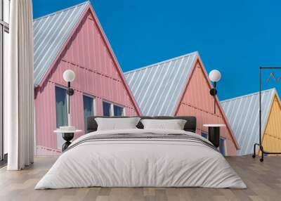 Lookup view of metal roof and gutter on row of new development colorful house with clear blue sky background Wall mural