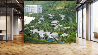 White sandy beach with multistory hotel resort and upscale neighborhood of two story white painted villas, swimming pool, lush green coconut palm trees, vacation home roof tile, luxury travel Wall mural