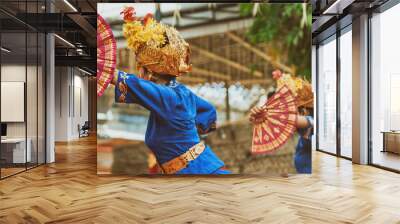 Asian travel background. Group of beautiful Balinese dancer women in traditional Sarong costumes with fans in hands dancing Legong dance. Arts, culture of Indonesian people, Bali island festivals. Wall mural