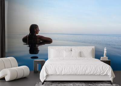 Happy girl enjoy on summer beach holiday. Young woman relaxing at edge of infinity swimming pool with sea view from hill top. Family cruise lifestyle, summer travel with kids on tropical islands. Wall mural