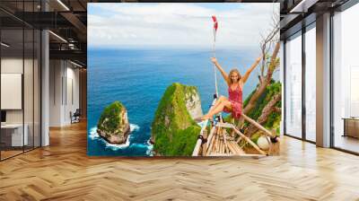 Happy girl have fun on summer beach holiday. Young woman relax at rock cliff above sea. Looking at beautiful view of coast. Healthy family lifestyle, summer travel on tropical island. Wall mural