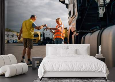 Mature woman and man at cargo warehouse, truck drivers delivery inspection  Wall mural