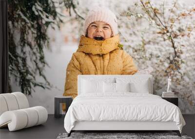 Toddler girl happy with snow day in winter. Playing outside on Christmas holiday Wall mural