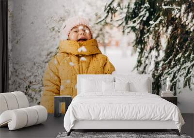 Toddler girl happy with snow day in winter. Playing outside on Christmas holiday Wall mural