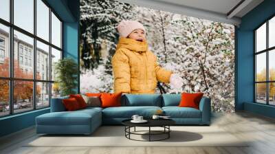 Toddler girl happy with snow day in winter. Playing outside on Christmas holiday Wall mural