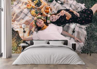 Two best friends on picnic in the field laying on the laid smiling top view friendship concept Wall mural