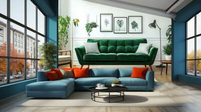 A modern living room with an emerald green sofa, white walls, and frames on the wall. A plant in front of it adds to its fresh atmosphere. The space is well-lit by floor lamps, creating an inviting am Wall mural