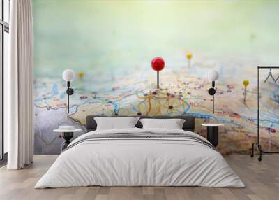 Pins on a geographic map curved like mountains. Pinning a location on a map with mountains. Adventure,  geography, mountaineering, hike and travel concept background. Wall mural