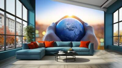 Planet Earth in the hands of a man against the background of the lights of the evening city. Concept and symbol on the theme of ecology, earth conservation, news and religion. Wall mural