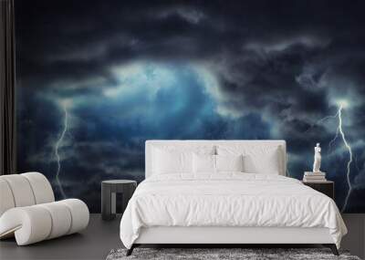 The rays of the sun in the gap between the clouds in the dark, gloomy sky. Stormy dark sky with black clouds and a strong wind. Panoramic view. Concept on the theme of weather, natural disasters. Wall mural