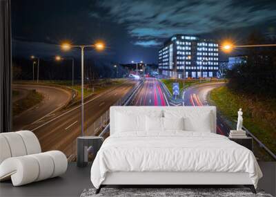 Long exposure of highway traffic at night. Intersection with a building under construction. Wall mural