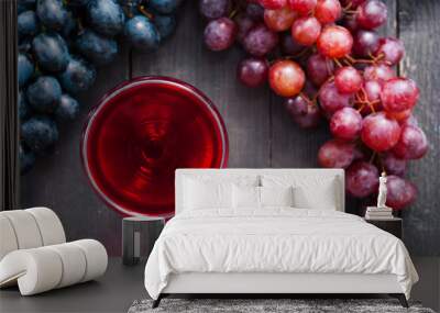 glass of red wine and grapes on black wooden table background Wall mural