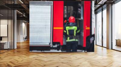 Group of fire men in uniform during fire fighting operation in the city streets, firefighters with the fire engine truck fighting vehicle in the background, emergency and rescue Wall mural