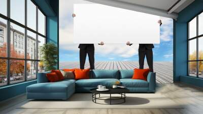 Men standing on wooden floor and lifting board Wall mural